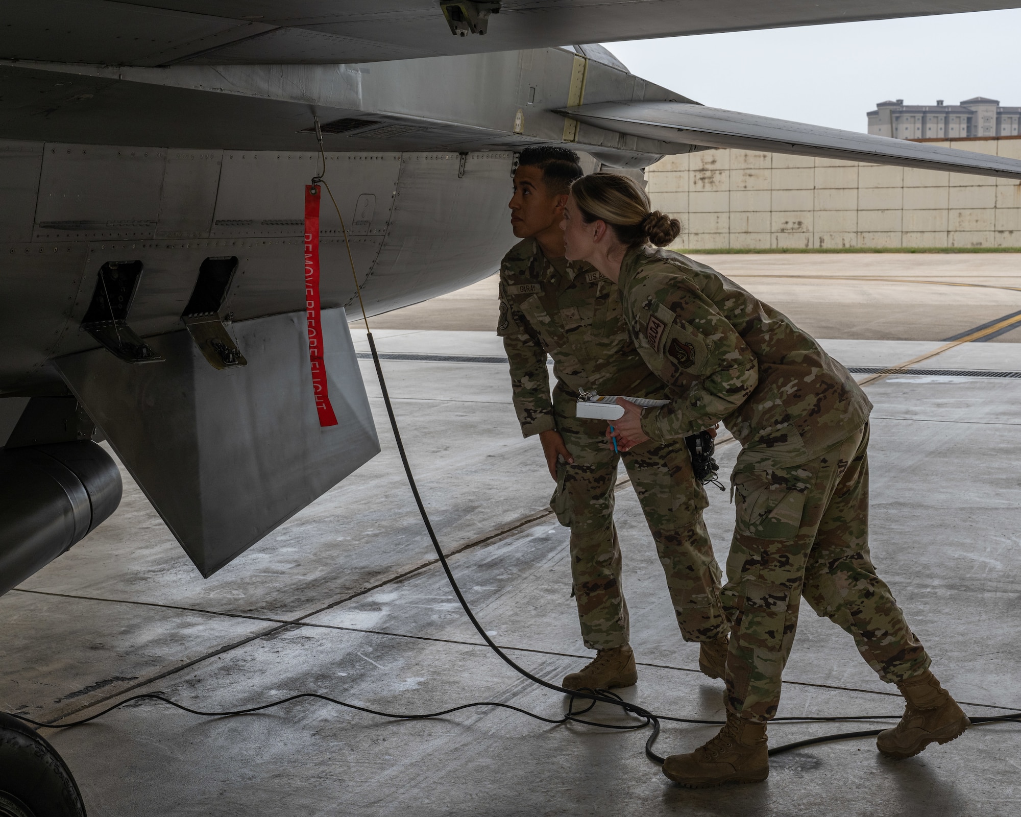 U.S. Air Force Tech. Sgt. Danielle Baillargeon,  80th Fighter Generation Squadron weapons team chief, and Senior Airman Marcos Garay, 80th FGS weapons crew member, check an F-16 Fighting Falcon aircraft for spent chaff and flares at Kunsan Air Base, Republic of Korea.