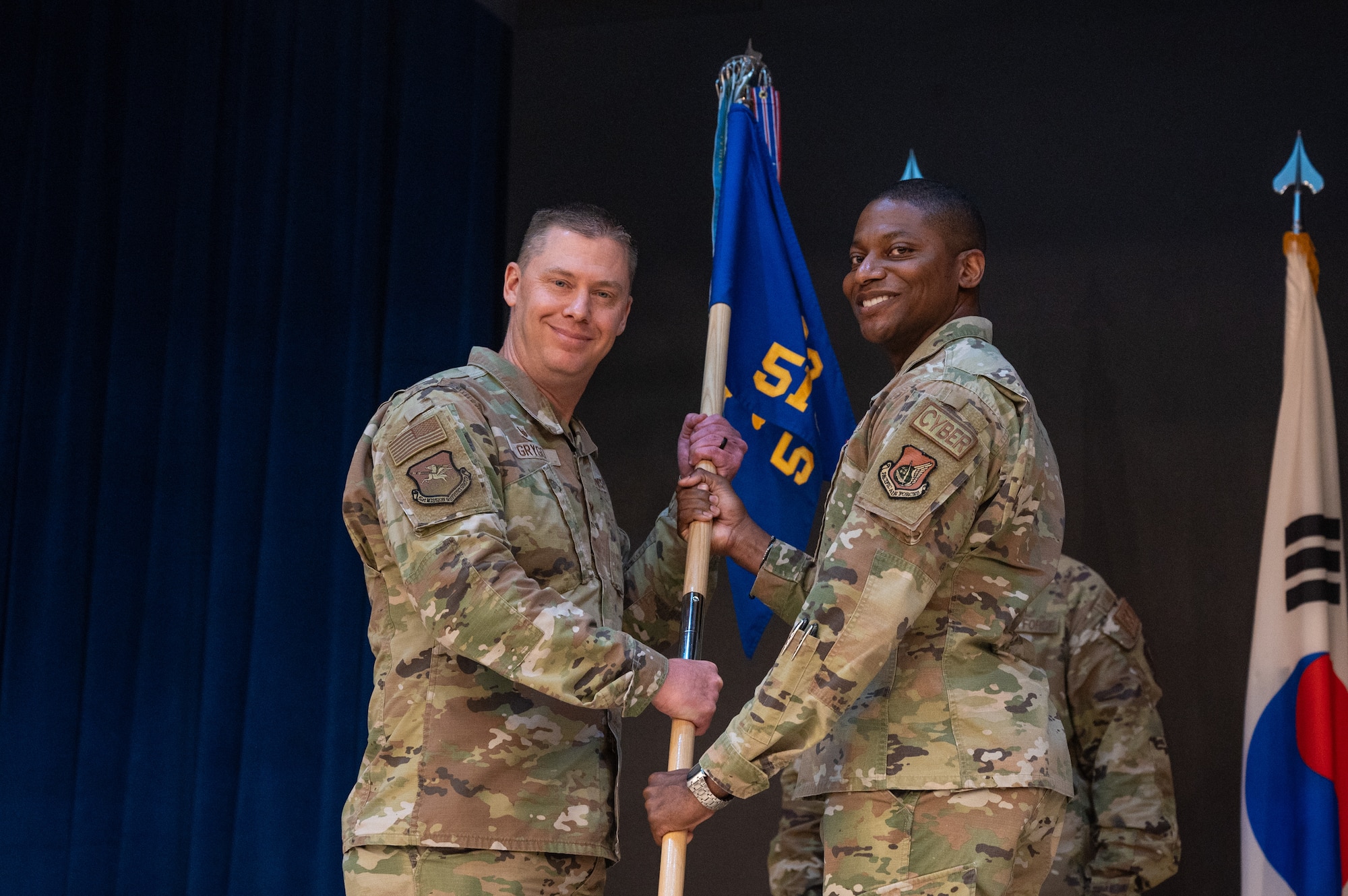 U.S. Air Force Lt. Col. Michael Newson,  right, relinquishes command of the 51st Communications Squadron to Col. Kyle Grygo, left, 51st Mission Support Group commander, during a change of command ceremony at Osan Air Base, Republic of Korea, June 21, 2024. Newson will move on to serve under the Secretary of the Air Force director of enterprise information technology at the Pentagon. A change of command ceremony marks a smooth leadership transition, essential for preserving unit cohesion within the 51st Fighter Wing. (U.S. Air Force photo by Staff Sgt. Christopher Tam)