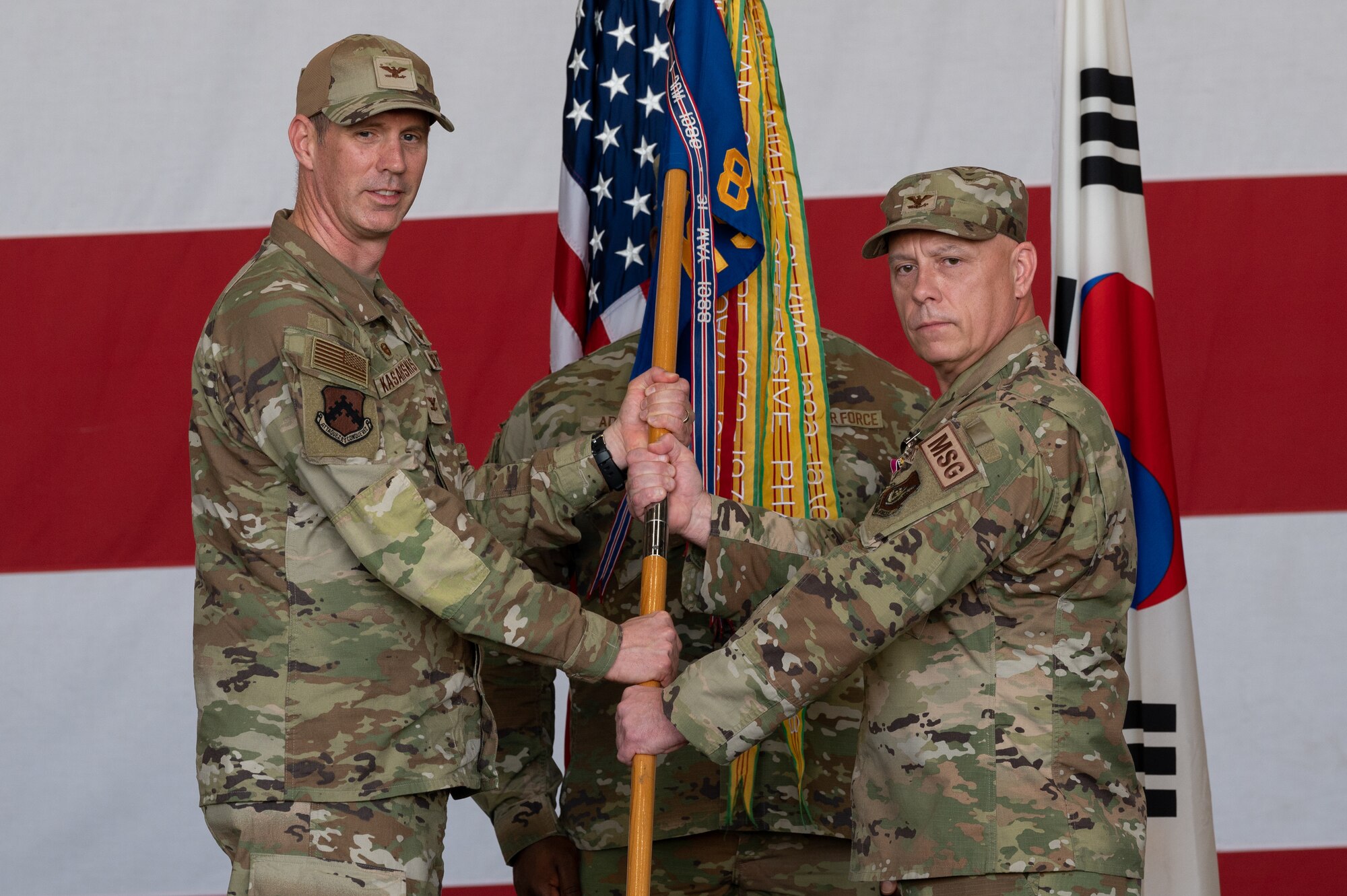 U.S. Air Force Col. Peter Kasarskis, left, 8th Fighter Wing commander, receives the 8th Mission Support Group guidon from Col. Christopher Lacek, 8th MSG outgoing commander, during the change of command ceremony at Kunsan Air Base, Republic of Korea.