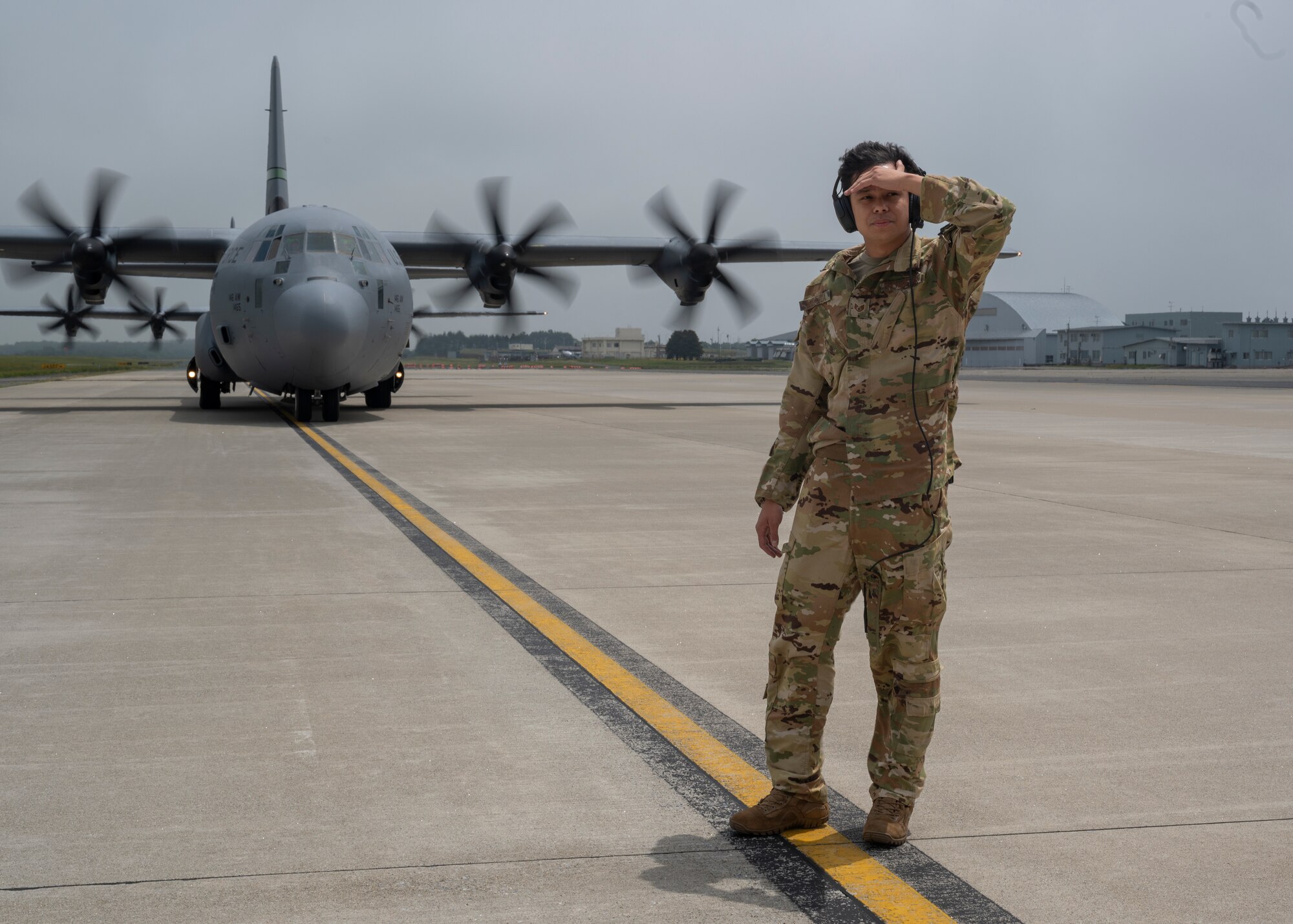 An airman stands in front of a U.S. Air National Guard C-130J Super Hercules assigned to the 115th Airlift Squadron before unloading personnel.