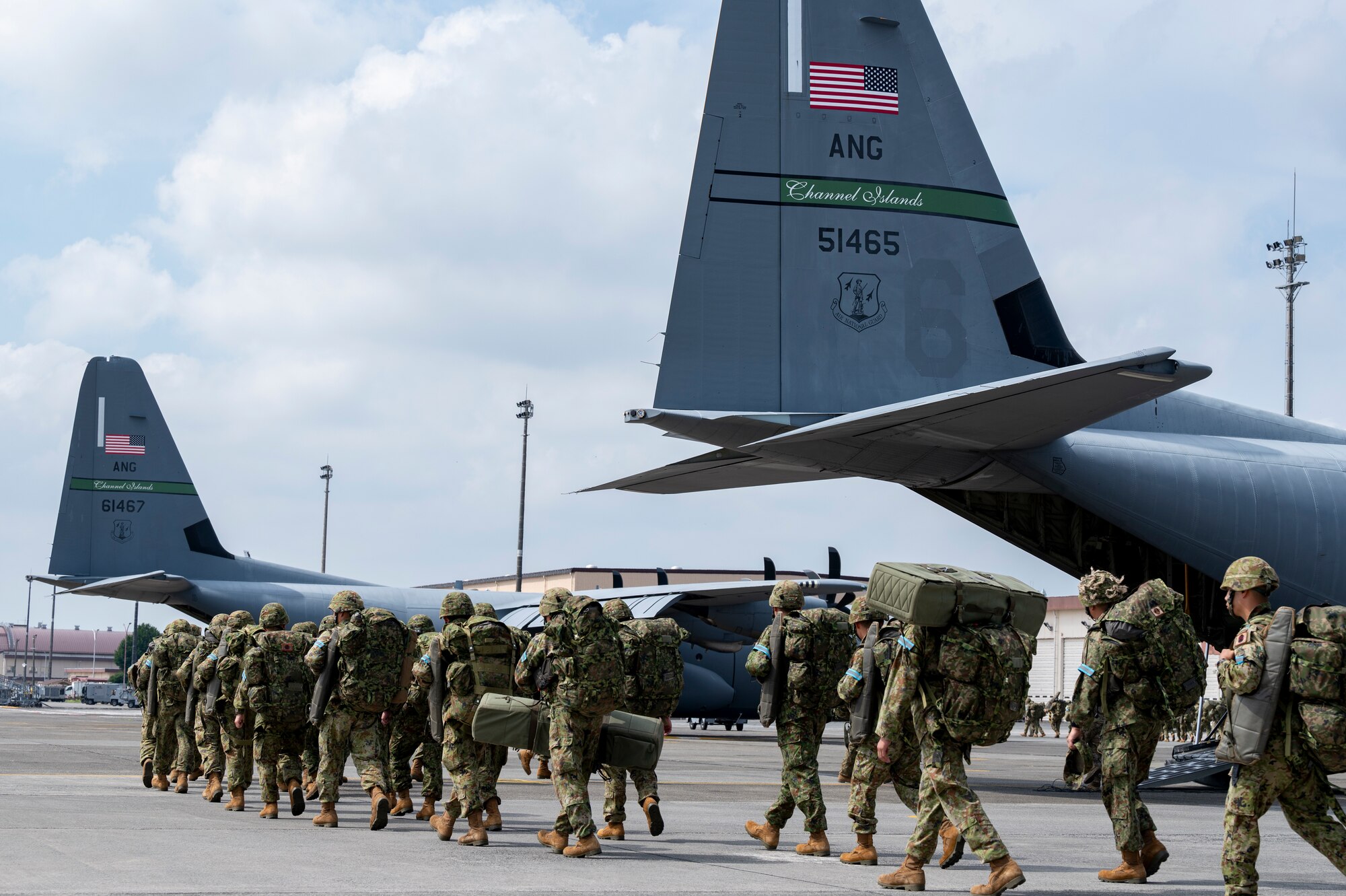 Japan Ground Self-Defense Force paratroopers assigned to the 1st Airborne Brigade prepare to board U.S. Air National Guard C-130J Super Hercules.