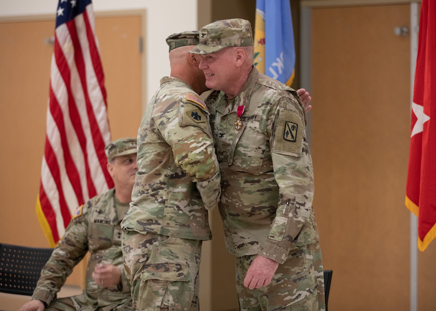Col. Johnnie Dale Moss, outgoing commander of the 45th Field Artillery Brigade, Oklahoma Army National Guard hugs incoming commander Lt. Col. William Kale Rogers during a change of command ceremony held at the Mustang Armed Forces Reserve Center in Mustang, Oklahoma, on June 15, 2024. The changing of command signifies the transfer of responsibility from outgoing to incoming commander. (Oklahoma National Guard photo by Pfc. Brooklyn Clark)