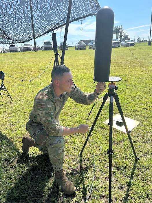 U.S. Air Force member assigned to the 85th Engineering Installation Squadron plug cable into radio equipment