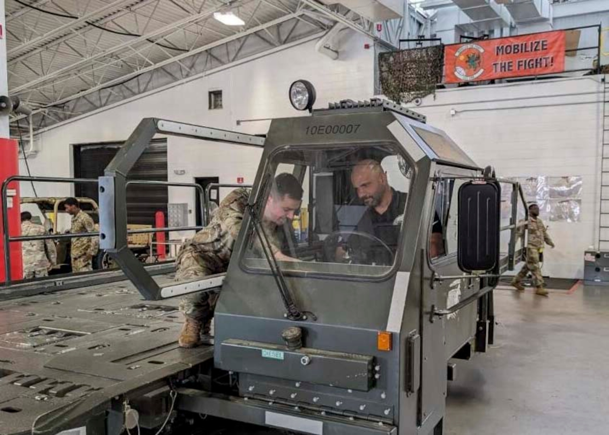 Coach Jamal Singleton, Philadelphia Eagles assistant coach, receives hands-on training to operate a 25K-loader from Senior Airman Jason Gresh, 621st Contingency Response Support Squadron aerial porter, June 10, 2024, at Joint Base McGuire-Dix-Lakehurst.