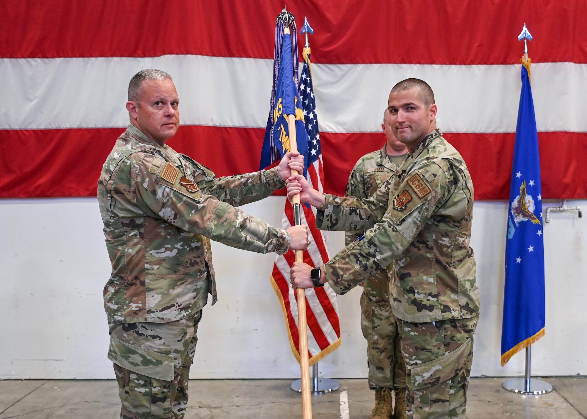A 377th Test and Evaluation Group commander, passes the 377th Test and Evaluation Group flag to the 377th TEG incoming commander, during a change of command ceremony at Vandenberg Space Force Base.