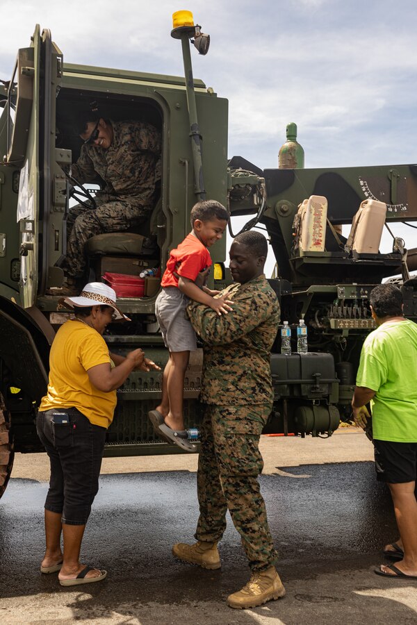 U.S. Marine Corps Sgt. Folly Amouzougan, an automotive maintenance technician with Combat Logistics Battalion 13, Combat Logistics Regiment 17, 1st Marine Logistics Group, assists a child out of a U.S. Marine Corps wrecker vehicle during a military equipment exposition as part of exercise Valiant Shield 24 at Palau International Airport, Airai, Palau, June 13, 2024. U.S. joint forces

conducting exercise Valiant Shield 24 held a military equipment exposition to offer insight into military operations and build relationships with the Palauan community. I Marine Expeditionary Force conducts exercises like Valiant Shield to enhance interoperability with allied and partner forces and expand the

operational capability of the Marine Air-Ground Task Force in the Indo-Pacific region. (U.S. Marine Corps photo by Lance Cpl. Hannah Hollerud)