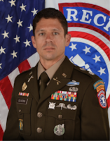 Photo of Army Lt. Col. wearing Army Green Service Uniform while posing in front of the American flag & United States Recruiting Command (USAREC) flag.