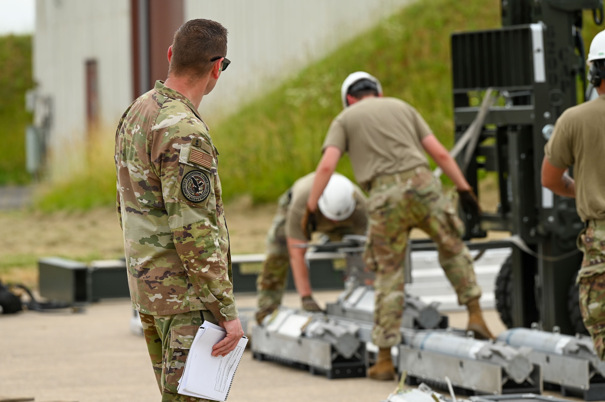 Airmen are inspected as they assemble the munitions assembly conveyor.