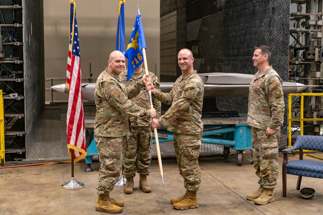 Lt. Col. Joseph Sabat, right center, takes the guidon from Arnold Engineering Development Complex 804th Test Group Commander Col. Jason Vap, left, to assume command of the AEDC 716th Test Squadron during a Change of Command ceremony June 18, 2024, at Arnold Air Force Base, Tenn., headquarters of AEDC. Also pictured is outgoing 716 TS commander Lt. Col. James Gresham, right. (U.S. Air Force photo by Keith Thornburgh)