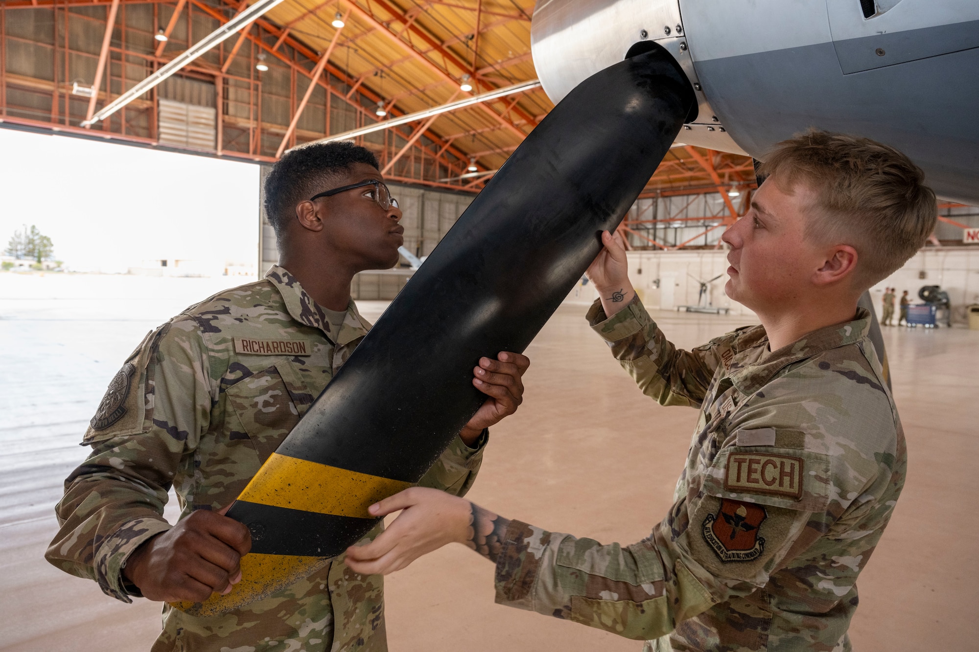 U.S. Air Force Airmen 1st Class Kennedy Richardson, left, and Justin Dacosta, 29th Aircraft Maintenance Unit avionics technicians, perform an MQ-9 Reaper prop inspection at Holloman Air Force Base, New Mexico, June 14, 2024. The Multi-Capable Airmen training program helps train and prepare Airmen in weapons, avionics and crew chief immersion for various tasks that contribute to the mission. (U.S. Air Force photo by Airman 1st Class Michelle Ferrari)