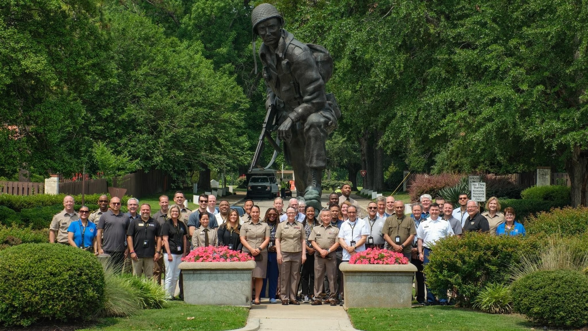 Large group of people standing below the Iron Mike statue.