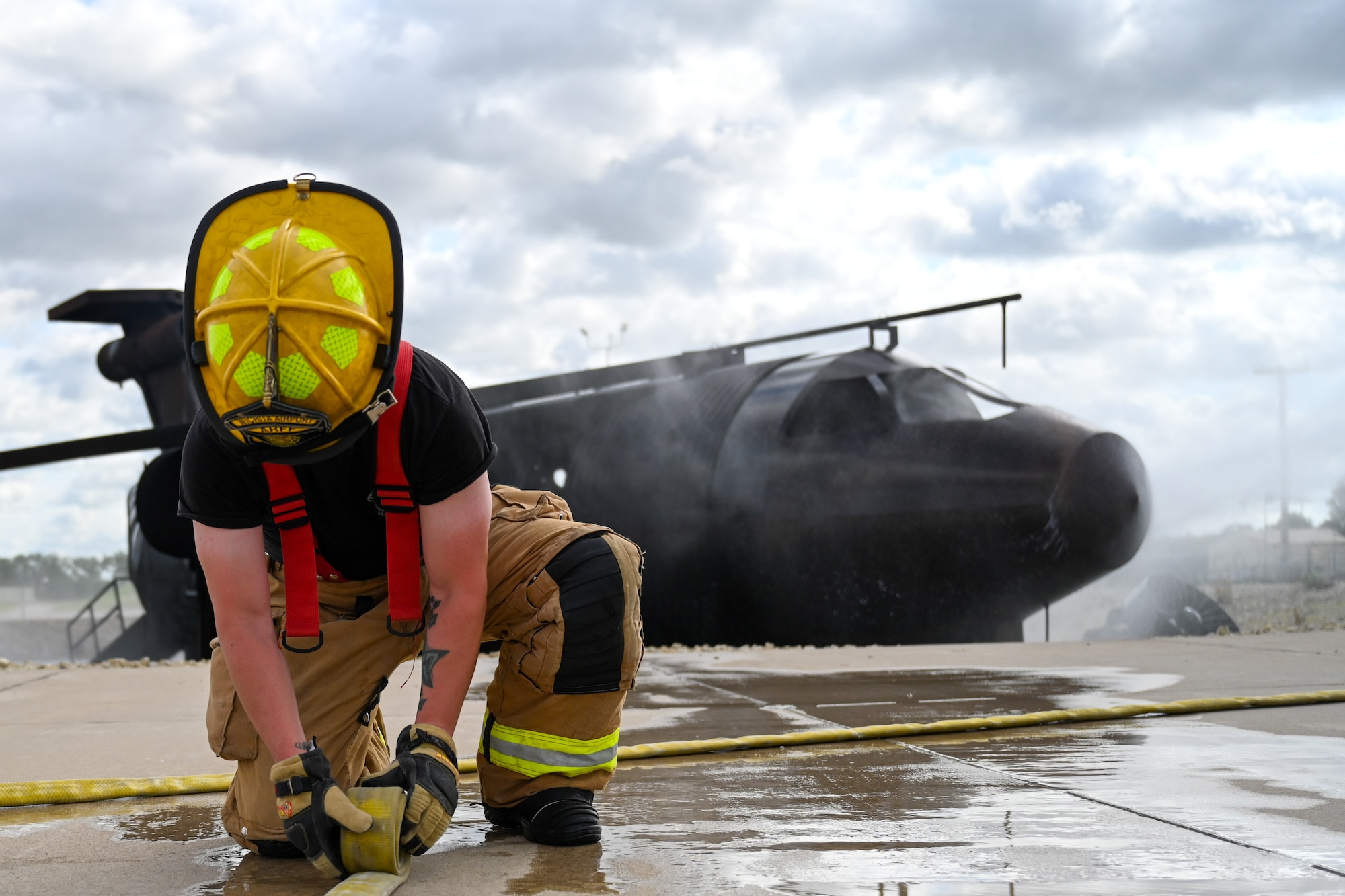 A firefighter from the Wichita Dwight D. Eisenhower National Airport rolls a hose during a training exercise June 18, 2024, at McConnell Air Force Base, Kansas. This was a bipartisan training exercise between firemen from the 22nd Civil Engineer Squadron and the Wichita airport. (U.S. Air Force photo by Senior Airman William Lunn)