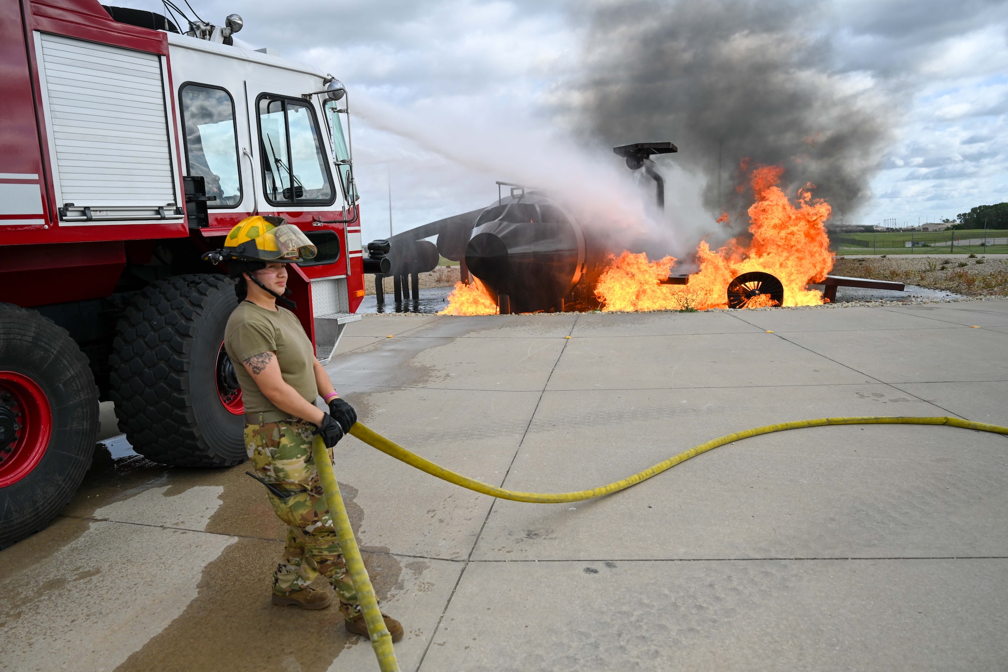 Airman 1st Class Angie Saravia, 22nd Civil Engineer Squadron firefighter, pulls a hose during an exercise June 18, 2024, at McConnell Air Force Base, Kansas. This was a bipartisan training exercise between firemen from McConnell and the Wichita Dwight D. Eisenhower National Airport. (U.S. Air Force photo by Senior Airman William Lunn)