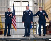 U.S. Air Force Col. John Burrell, incoming 5th Operations Group (5th OG) commander (center), is congratulated by U.S. Air Force Col. Christopher Cain, outgoing 5th Operations Group commander (right), and Col. Daniel Hoadley, 5th Bomb Wing commander (left), during the 5th OG change of command ceremony at Minot Air Force Base, North Dakota, June 21, 2024. Before taking command of the 5th OG Burrell was the Nuclear Operations Division Chief, the Pentagon Arlington, Virginia. Responsible for standardizing Nuclear Command and Control operations, policy, and Nuclear Surety across the National Military Command System. (U.S. Air Force photo by Airman 1st Class Luis Gomez)