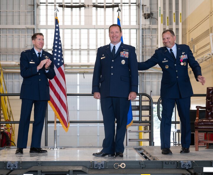 U.S. Air Force Col. John Burrell, incoming 5th Operations Group (5th OG) commander (center), is congratulated by U.S. Air Force Col. Christopher Cain, outgoing 5th Operations Group commander (right), and Col. Daniel Hoadley, 5th Bomb Wing commander (left), during the 5th OG change of command ceremony at Minot Air Force Base, North Dakota, June 21, 2024. Before taking command of the 5th OG Burrell was the Nuclear Operations Division Chief, the Pentagon Arlington, Virginia. Responsible for standardizing Nuclear Command and Control operations, policy, and Nuclear Surety across the National Military Command System. (U.S. Air Force photo by Airman 1st Class Luis Gomez)