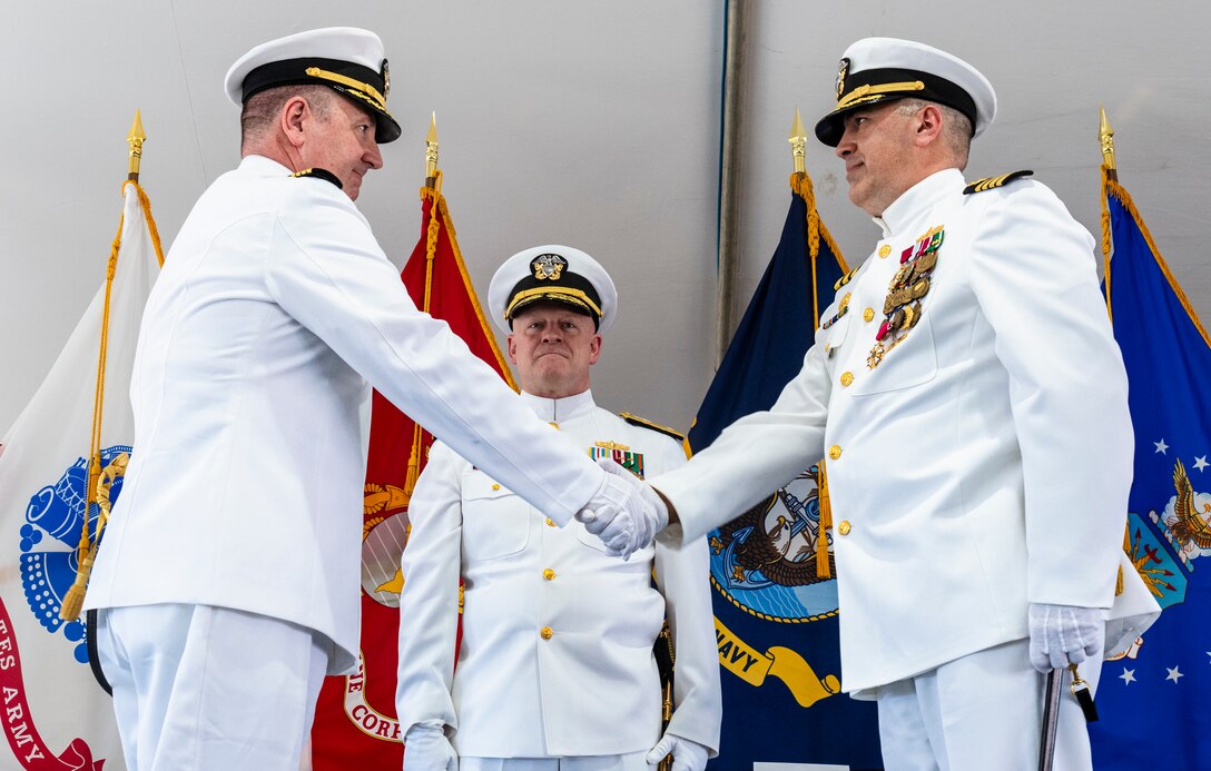 IMAGE:  Capt. Joseph Oravec (left) shakes hands with Capt. Philip Mlynarski after assuming command of Naval Surface Warfare Center Dahlgren Division during a change of command ceremony June 21. Rear Adm. Thomas Dickinson (center), commander of Naval Surface Warfare Center and Naval Undersea Warfare Center, delivered the ceremony’s opening remarks.