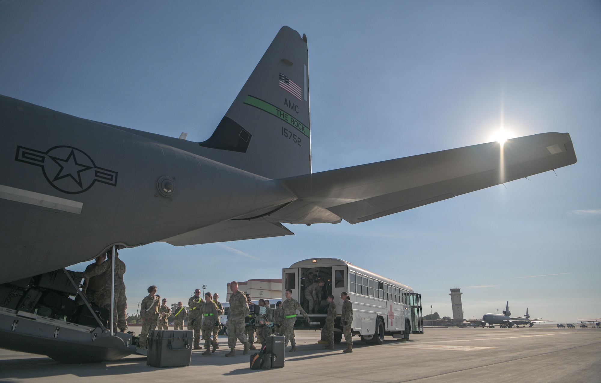 Airmen transport simulated patients from an ambulance bus onto an aircraft