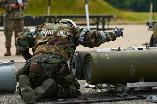U.S. Air Force Airmen from 1st Munitions Squadron assemble guided bomb unit 32 smart bombs in mission-oriented protective posture (MOPP) gear for the Air Force Combat Operation Competition at Joint Base Langley-Eustis, Virginia, June 5, 2024. Airmen are required to don MOPP gear in the case of a chemical, biological, radiological or nuclear emergency. (U.S. Air Force photo by Airman 1st Class Gerald Ligeralde)