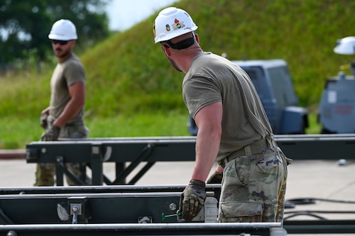 U.S. Air Force Airmen from 1st Munitions Squadron start construction on a munitions assembly conveyor (MAC) in preparation for the Air Force Combat Operation Competition, at Joint Base Langley- Eustis, Virginia, June 3, 2024. The MAC is used to transport munitions systems and explosives. (U.S. Air Force Photo by Airman 1st Class Gerald Ligeralde)