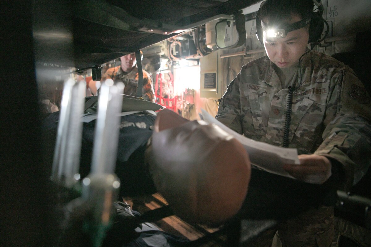 An airman reads a simulated medical scenario on an aircraft