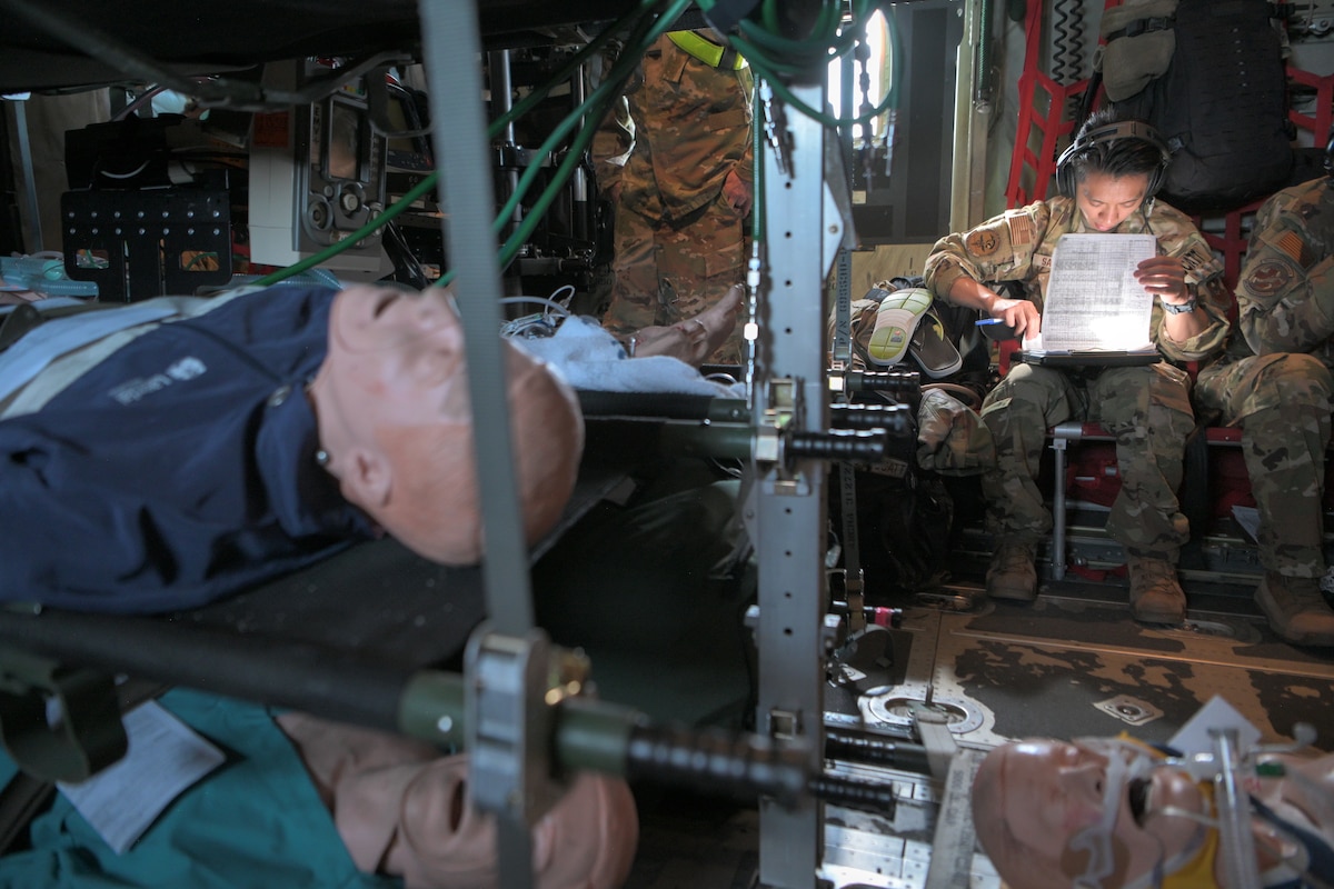An airman records simulated patient notes on an aircraft
