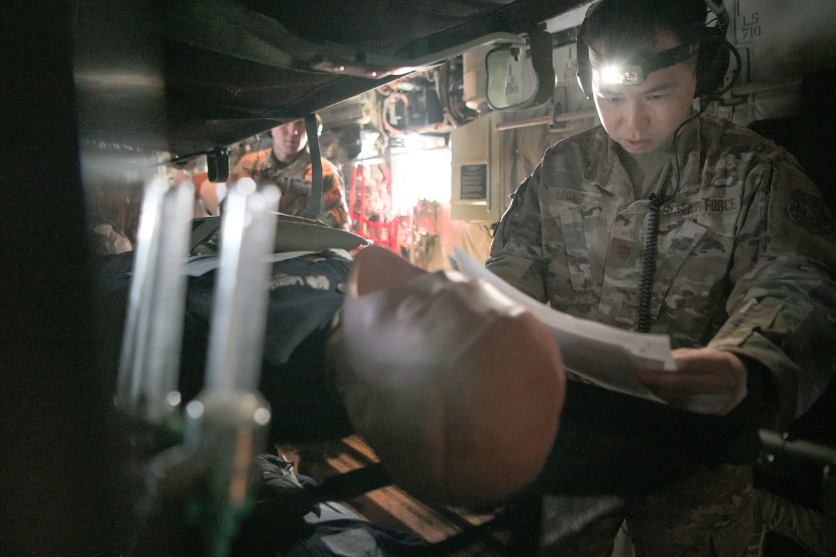 An airman reads a simulated medical scenario on an aircraft