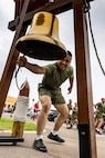 A new U.S. Marine with Bravo Company, 1st Recruit Training Battalion, rings a liberty bell during their motivational run at Marine Corps Recruit Depot San Diego, California, June 20, 2024. The company motivational run is a three-mile cadence run conducted around the Depot, the last physical training event the Marines will conduct before they graduate from MCRD San Diego and the first time their friends and families will see their newly transformed U.S. Marines. (U.S. Marine Corps photo by Sgt. Jesse K. Carter-Powell)