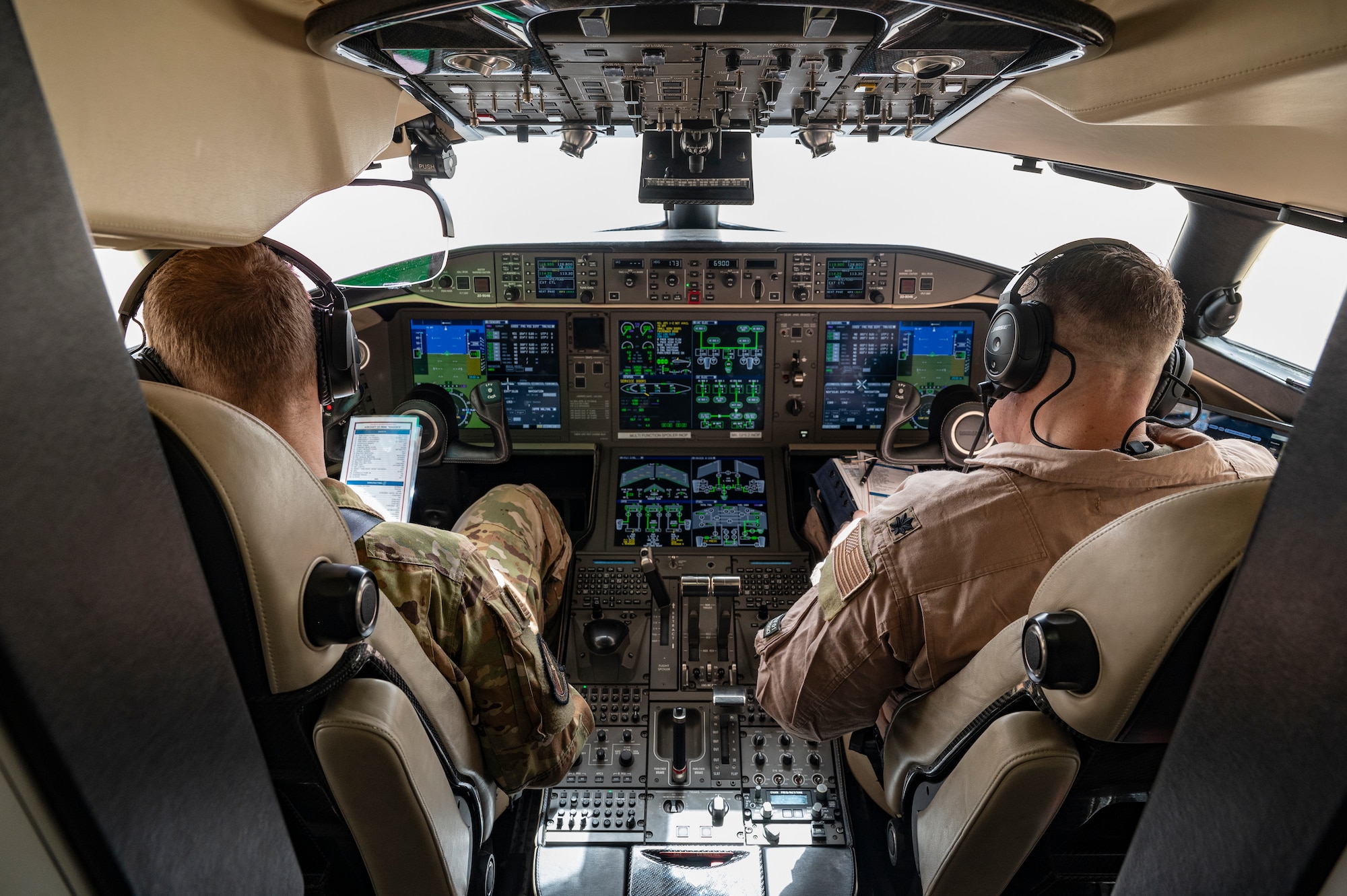 Two U.S. Air Force E-11A Aircraft pilots assigned to the 430th Expeditionary Electronic Combat Squadron perform preflight tasks at an undisclosed location within the U.S. Central Command area of responsibility, May 7, 2024. The E-11s host the only formal training unit in Air Force Central Command. (U.S. Air Force photo)