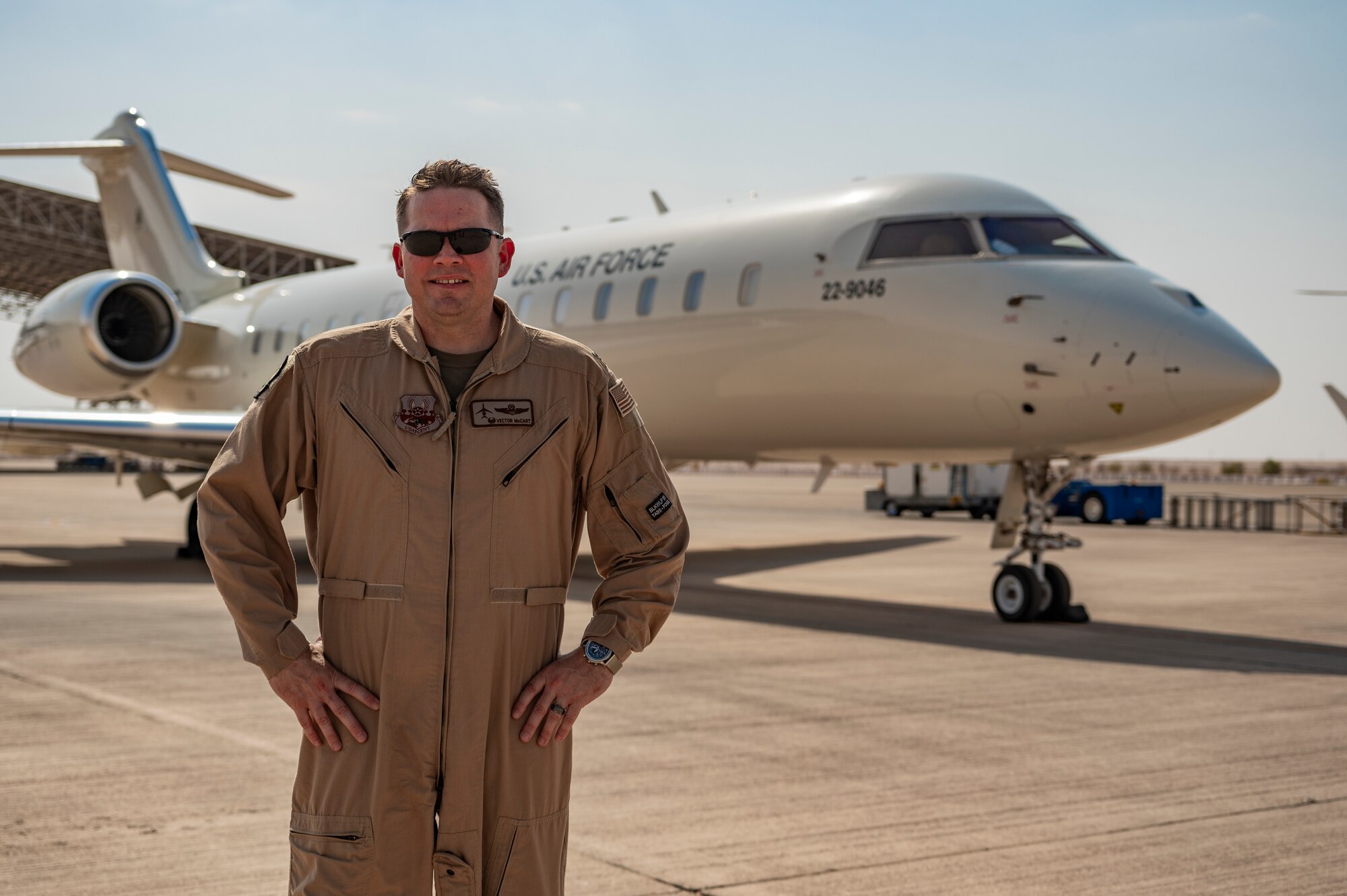 U.S. Air Force E-11A Aircraft pilot assigned to the 430th Expeditionary Electronic Combat Squadron poses for a photo at an undisclosed location within the U.S. Central Command area of responsibility, June 20, 2024. By consolidating critical data from various sources, the E-11 ensures seamless coordination among different aircraft, even when line-of-sight communication is limited. (U.S. Air Force photo)