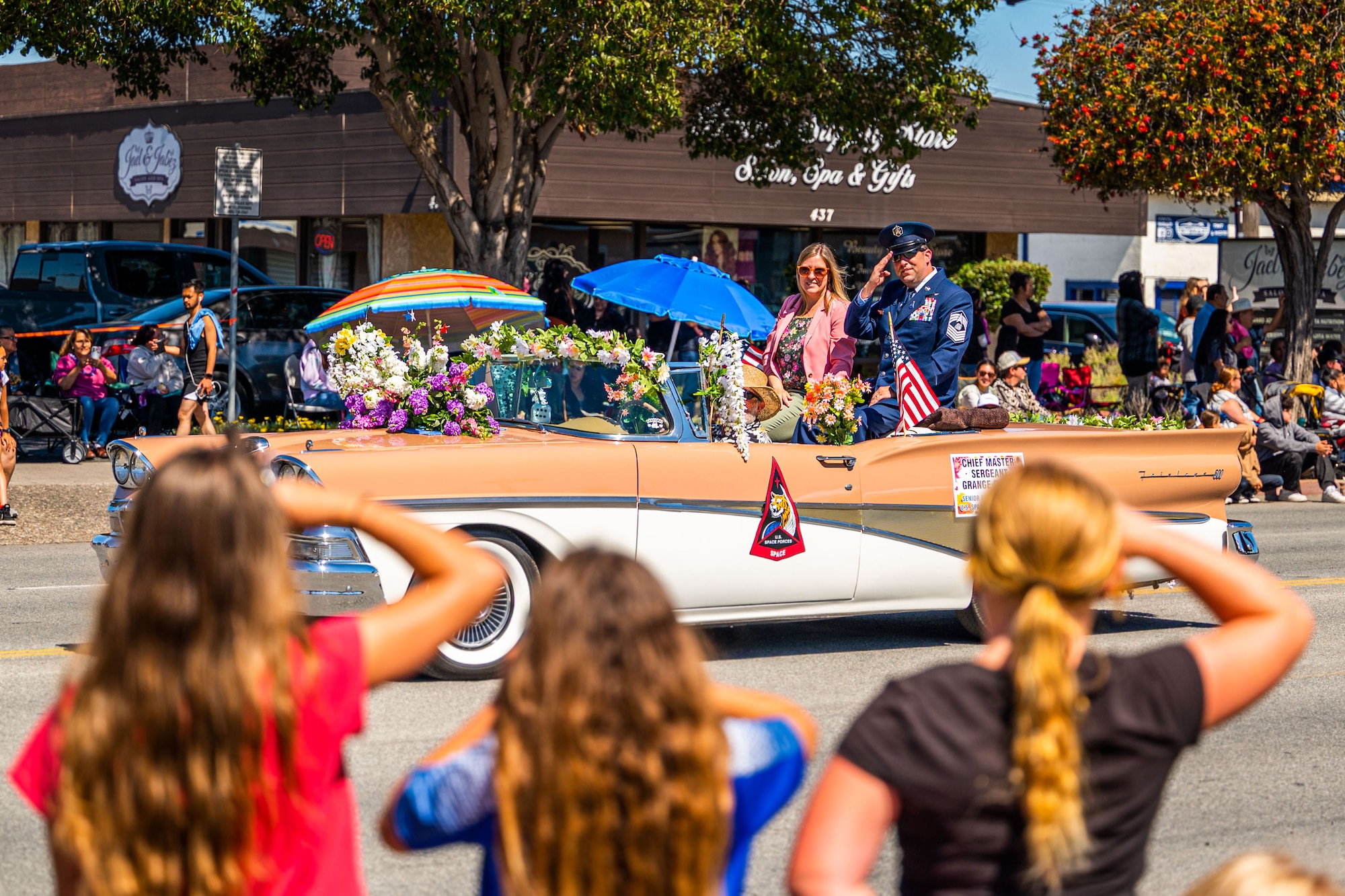 U.S. Space Force Chief Master Sgt. Grange S. Coffin, U.S. Space Forces - Space command senior enlisted leader, and his wife salute viewers of a parade from the back of a convertible car during the Lompoc Flower Festival Parade.