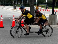 Greg Quarles pilots the tandem bike in the cycling competition for Army veteran Henry Escobedo of Team Army