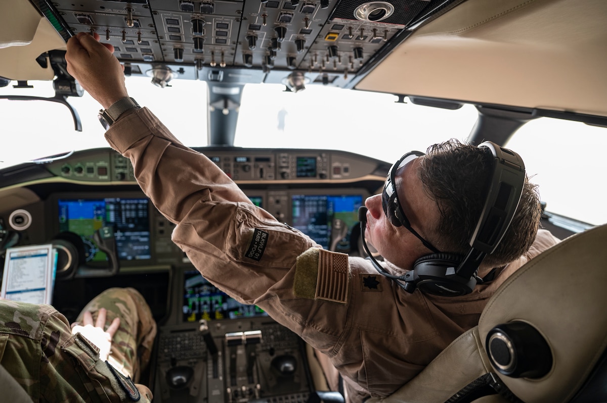 A U.S. Air Force E-11A Aircraft pilot assigned to the 430th Expeditionary Electronic Combat Squadron performs a preflight check at an undisclosed location within the U.S. Central Command area of responsibility, May 7, 2024. When satellite phones are ineffective due to line-of-sight constraints, the E-11 steps in as a data translator. It bridges communication gaps between different airframes, allowing effective collaboration among U.S. and UK airlift assets during airdrop missions. (U.S. Air Force photo)
