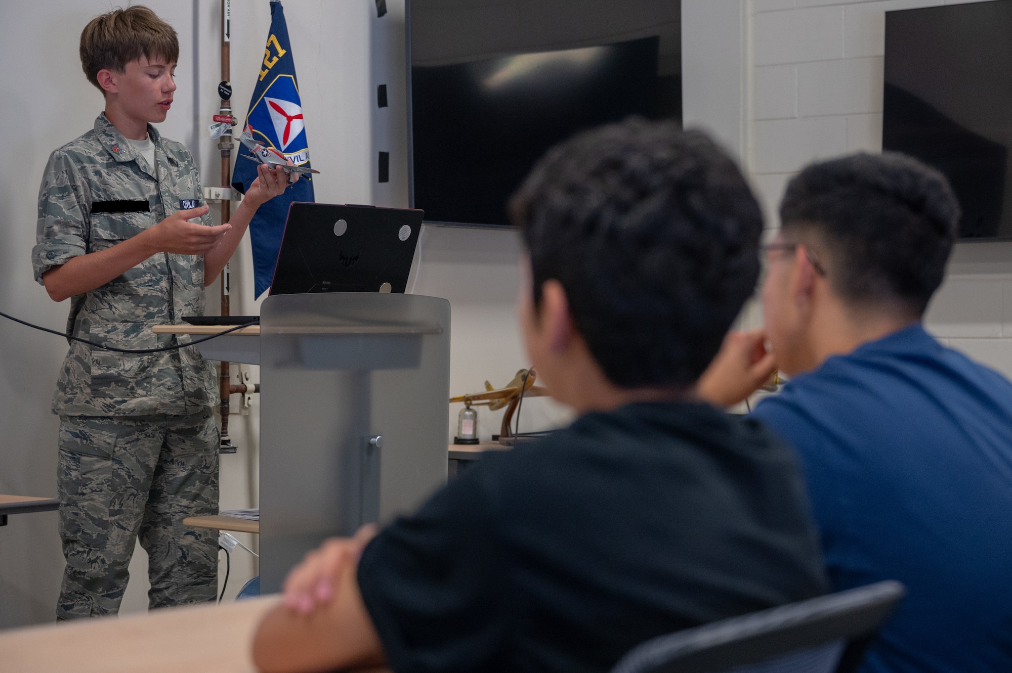 A Civil Air Patrol cadet from Squadron NHQ-127 teaches a lesson on the principles of aviation during a youth aviation day at Osan Air Base, Republic of Korea, June 15, 2024. CAP Squadron NHQ-127 is based out of Osan AB and is a federally chartered, non-profit corporation of volunteers who serve as an auxiliary to the U.S. Air Force. (U.S. Air Force photo by Airman 1st Class Chase Verzaal) (This photo has been altered for security purposes.)