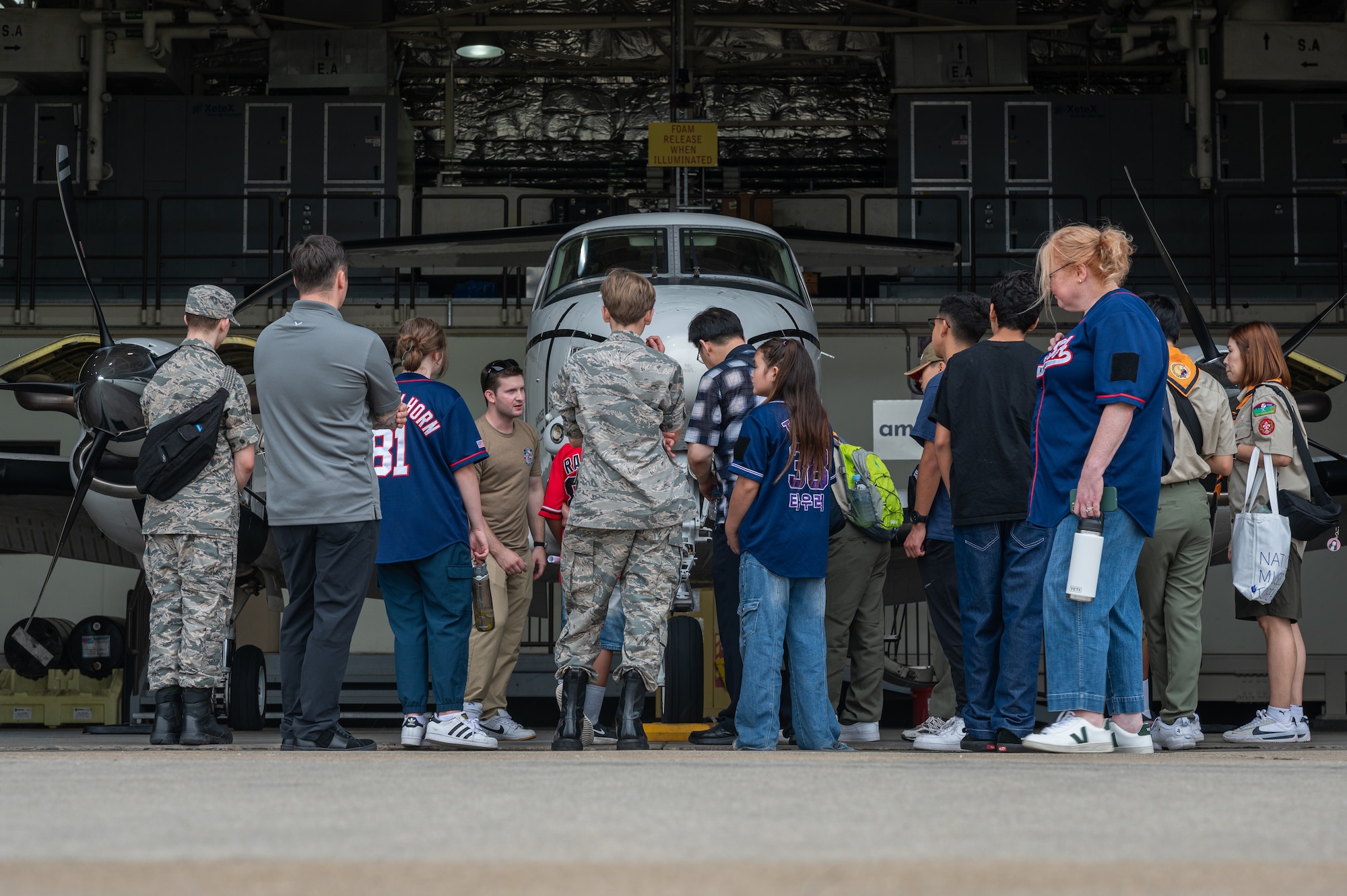 Participants of a youth aviation day observe a U.S. Army C-12 Huron military passenger and transport aircraft at Osan Air Base, Republic of Korea, June 15, 2024. Service members from the participating base organizations volunteered their time to teach the event attendees about the different organizations at Osan AB that contribute to ensuring that the aviators remain ready to “Fight Tonight.” (U.S. Air Force photo by Airman 1st Class Chase Verzaal)