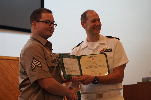 Yorktown, Va. (June 20, 2024) Sergeant Erik Johnson is presented with the Army Achievement Medal for his role as the Army Honor Graduate of the Tri-Service Optician School’s (TOPS) class 24-005 commencement ceremony by Commander Christopher DeAngelis, Director of the Tri-Service Optician School. The commencement ceremony was held at Nelson Chapel onboard Naval Weapons Station (NWS) Yorktown. The mission of TOPS is to provide formal optical training to Army Optical Laboratory Specialist MOS (68H) and Navy Hospital Corpsman (NEC L19A) students with quality training through a 24-week, DoD, uniformed services school on the subjects of ophthalmic dispensing, ophthalmic fabrication and clinical optics. Upon completing the required curriculum, graduates are immediately able to function as an independent optician in any military environment. (U.S. Navy Photo by Max Lonzanida/Released)