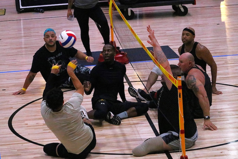 Wounded warriors practice seated volleyball.