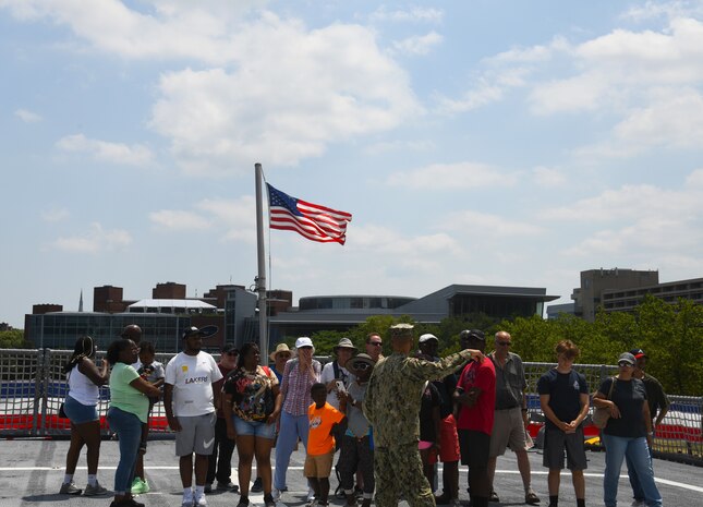 A sailor from the Littoral Combat Ship Squadron (COMLCSRON) 2, gives a tour to visitors on board the littoral combat ship USS Marinette (LCS 25), during Maryland Fleet Week and Flyover Baltimore, 18 June.