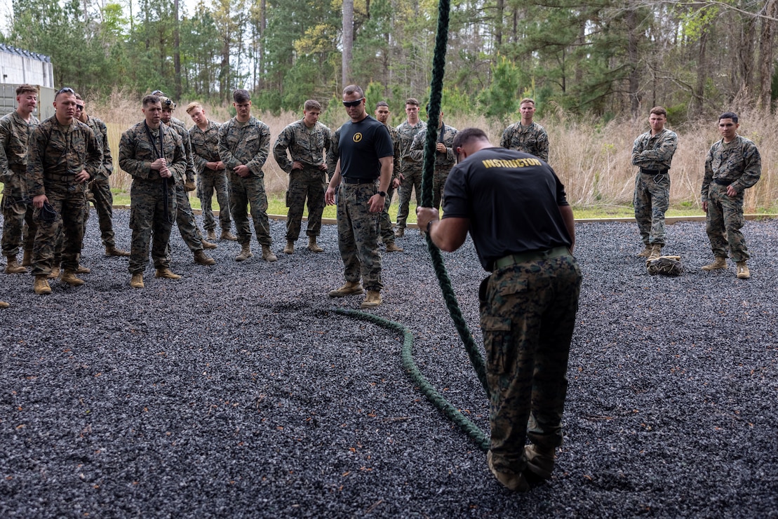 U.S Marine Corps Gunnery Sgt. John Cohee JR., a ropes and recovery instructor, left, and Capt.Zachary Wheeler, ropes and recovery branch officer in charge, right, with II Marine Expeditionary Force, Expeditionary Operations Training Group (EOTG), demonstrate proper rope descension duringFast Ropes Master Course (FRMC),aboard Marine Corps Base Stone Bay North Carolina, March 27, 2023. FRMC is an opportunity for EOTG to train and certify the 26th Marine Expeditionary Unit as fast rope masters, giving them the ability to expediently descend a rope into restrictive terrain where landing an aircraft is not possible. The EOTG staff consists of close-knit professionals, dedicated to ensuring that deploying MEUs are ready and capable to support geographic combatant commanders and respond to crises events around the globe. (U.S. Marine Corps photo by Cpl. Marc Imprevert)