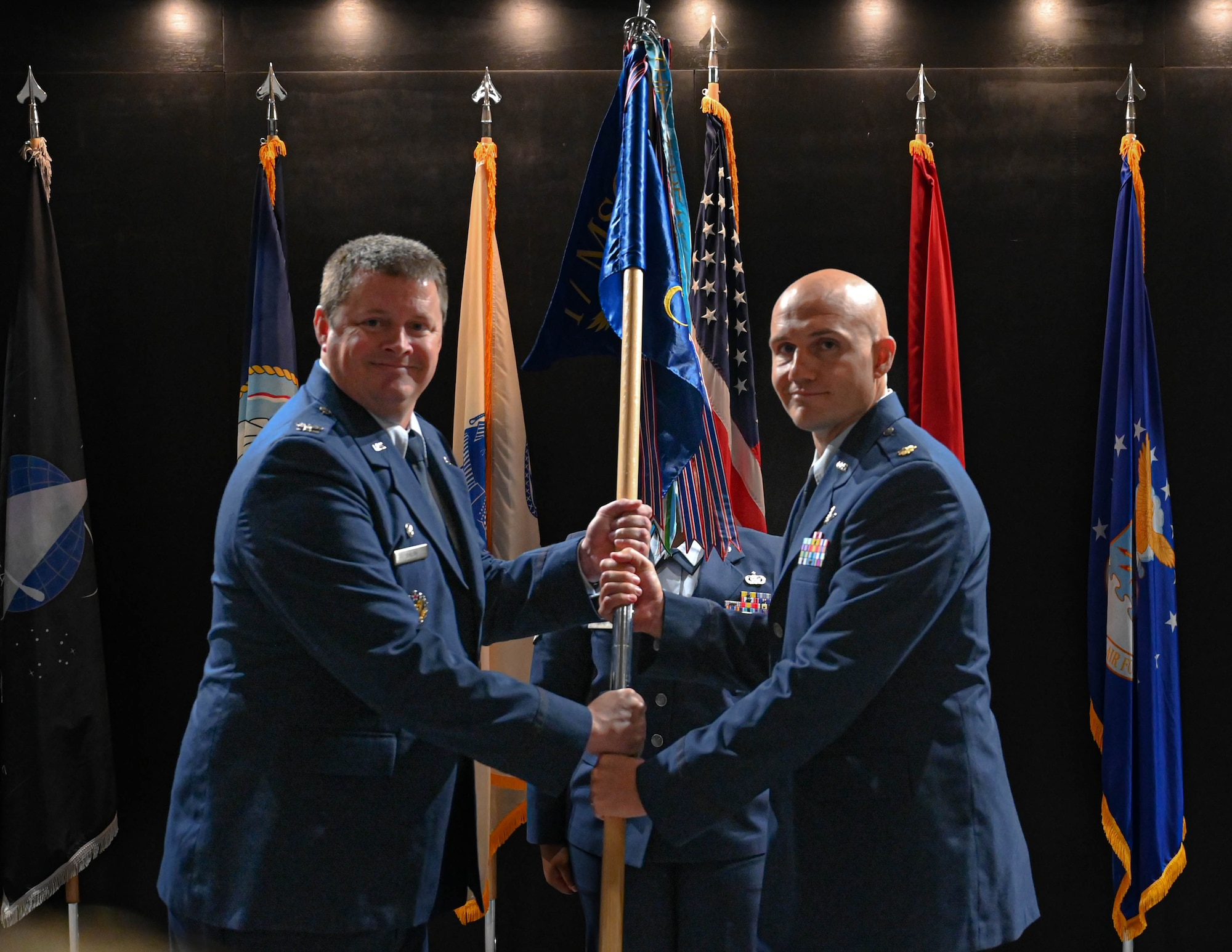 U.S. Air Force Col. Timothy Dalby, 17th Mission Support Group commander, passes the guidon to Maj. Alan Geason, incoming 17th Communications Squadron commander, during the 17th CS assumption of command ceremony at the Powell Event Center, Goodfellow Air Force Base, Texas, June 20, 2024. The passing of the guidon to Geason signifies him taking command of the 17th CS. (U.S. Air Force photo by Senior Airman Zach Heimbuch)