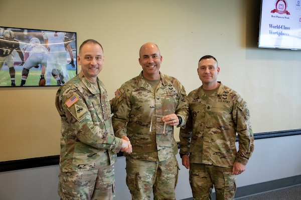 Maj. Gen. William Graham, U.S. Army Corps of Engineers deputy chief of engineers and deputy commanding general, and Command Sgt. Maj. Douglas Galick, USACE command sergeant major, presents the Best Places to Work Award to Col. Sebastien Joly, Huntsville Center commander, May 9 in Washington, D.C.