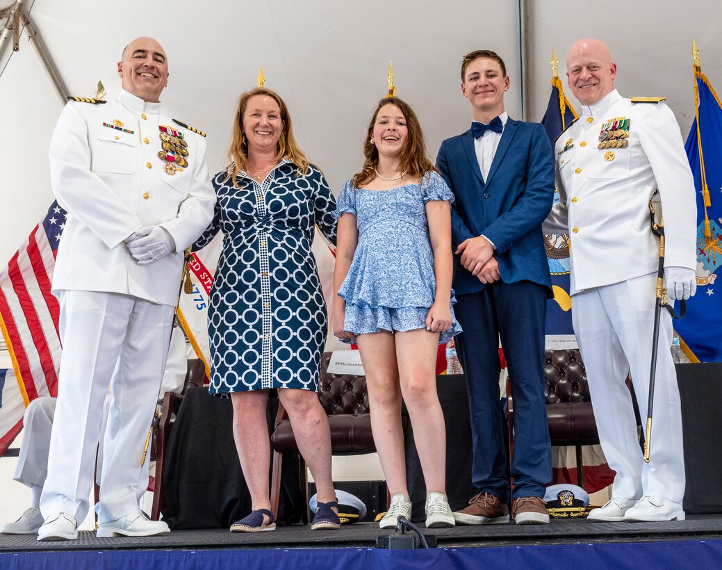 IMAGE: DAHLGREN, Va. – Capt. Philip Mlynarski (left) stands with his family, wife Leah, daughter Kiana and son Gabriel after Rear Adm. Thomas Dickinson (right) recognized them for their support of Mlynarski during his retirement ceremony at Naval Surface Warfare Center Dahlgren Division (NSWCDD) June 21. Mlynarski served as NSWCDD’s 47th commanding officer in the final two years of his 26-year career. (NSWCDD photo by Dave Ellis)
