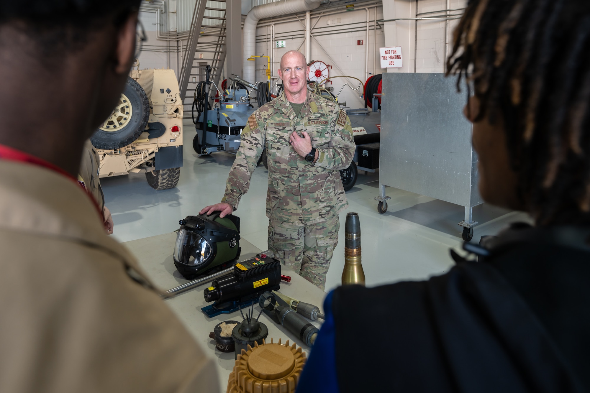 Master Sgt. Dustin Turner, an explosive ordnance disposal specialist assigned to the 123rd Airlift Wing, talks to students from Shawnee High School’s Navy JROTC program about his work disabling munitions during their tour of the Kentucky Air National Guard Base in Louisville, Ky., March 14, 2024. The base is home to about 1,200 Airmen and eight C-130J Super Hercules aircraft, with missions spanning the gamut from tactical airlift, special operations, disaster response, explosive ordnance disposal and aircraft maintenance to civil engineering, cyber communications, security forces, medical care and logistics. (U.S. Air National Guard photo by Dale Greer)