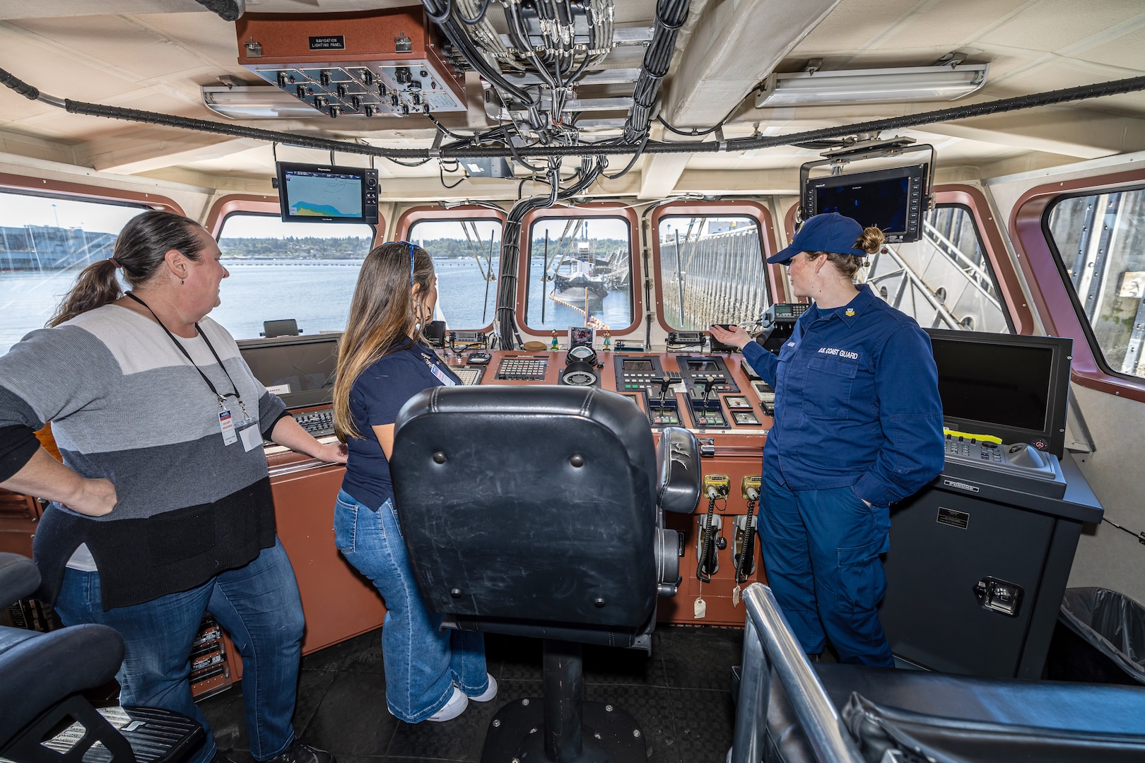 Petty Officer First Class Keisha Kerr leads a tour of USCGC Sea Lion (WPB-87352) June 6, 2024, for Washington Emergency Management Division employees Sarah Foster and Casey Broom at Puget Sound Naval Shipyard & Intermediate Maintenance Facility in Bremerton, Washington. (U.S. Navy photo by Jeb Fach)