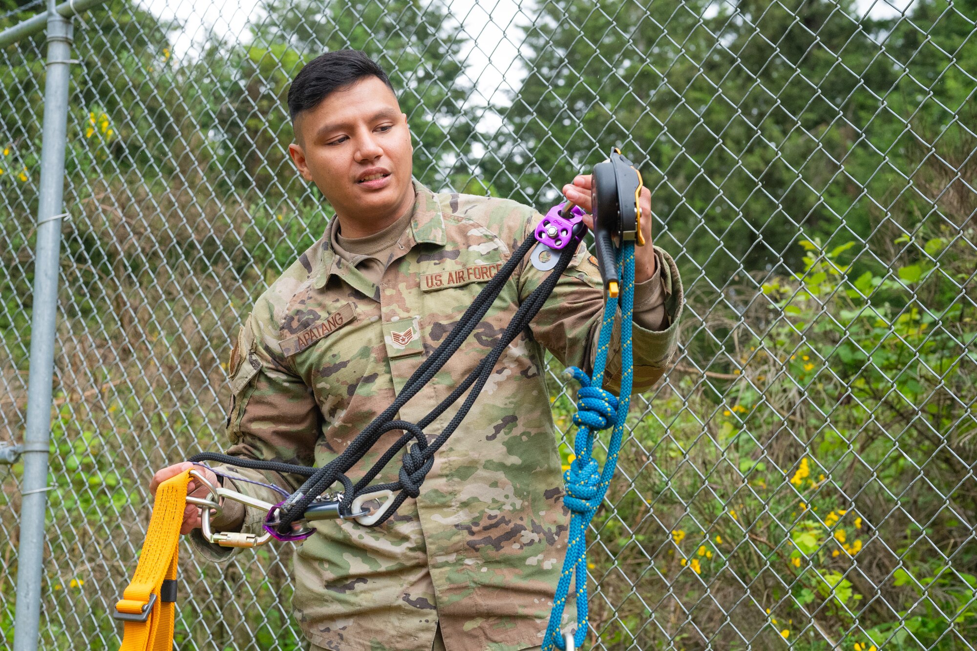 U.S. Air Force Staff Sgt. Christian Apatang, a cable and antenna systems technician supervisor with the 627th Communications Squadron, checks emergency rescue equipment functionality before an antenna tower inspection at Joint Base Lewis-McChord, Washington, May 28, 2024. Cable and antenna systems Airmen are required to take safety precautions while working in the field. (U.S. Air Force photo by Airman 1st Class Benjamin Riddle)