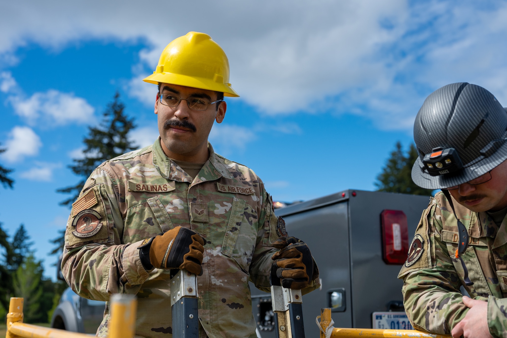 U.S. Air Force Senior Airman Hector Salinas, a cable and antenna systems technician with the 627th Communications Squadron, left, and Tech. Sgt. Jayden DeBolt, NCO in charge of cable and antenna operations with the 627th CS, secure manhole maintenance safety equipment at Joint Base Lewis-McChord, Washington, May 28, 2024. Cable and antenna systems Airmen work closely to ensure safety procedures are met and assist each other during operations. (U.S. Air Force photo by Airman 1st Class Benjamin Riddle)