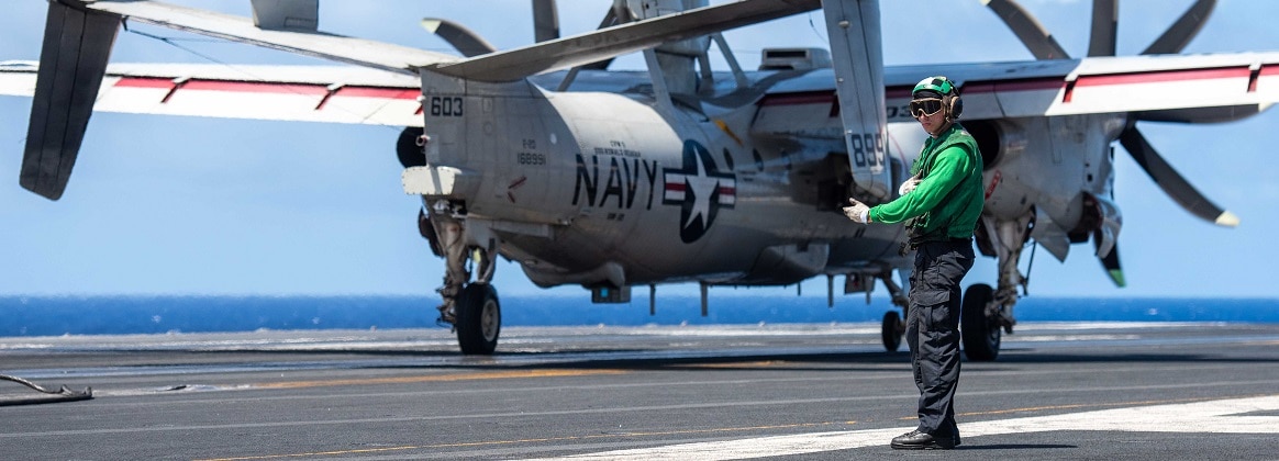 Aviation Boatswain’s Mate Airman Carnell Hill, from Lexington, South Carolina, signals the retraction of the arresting gear wire.