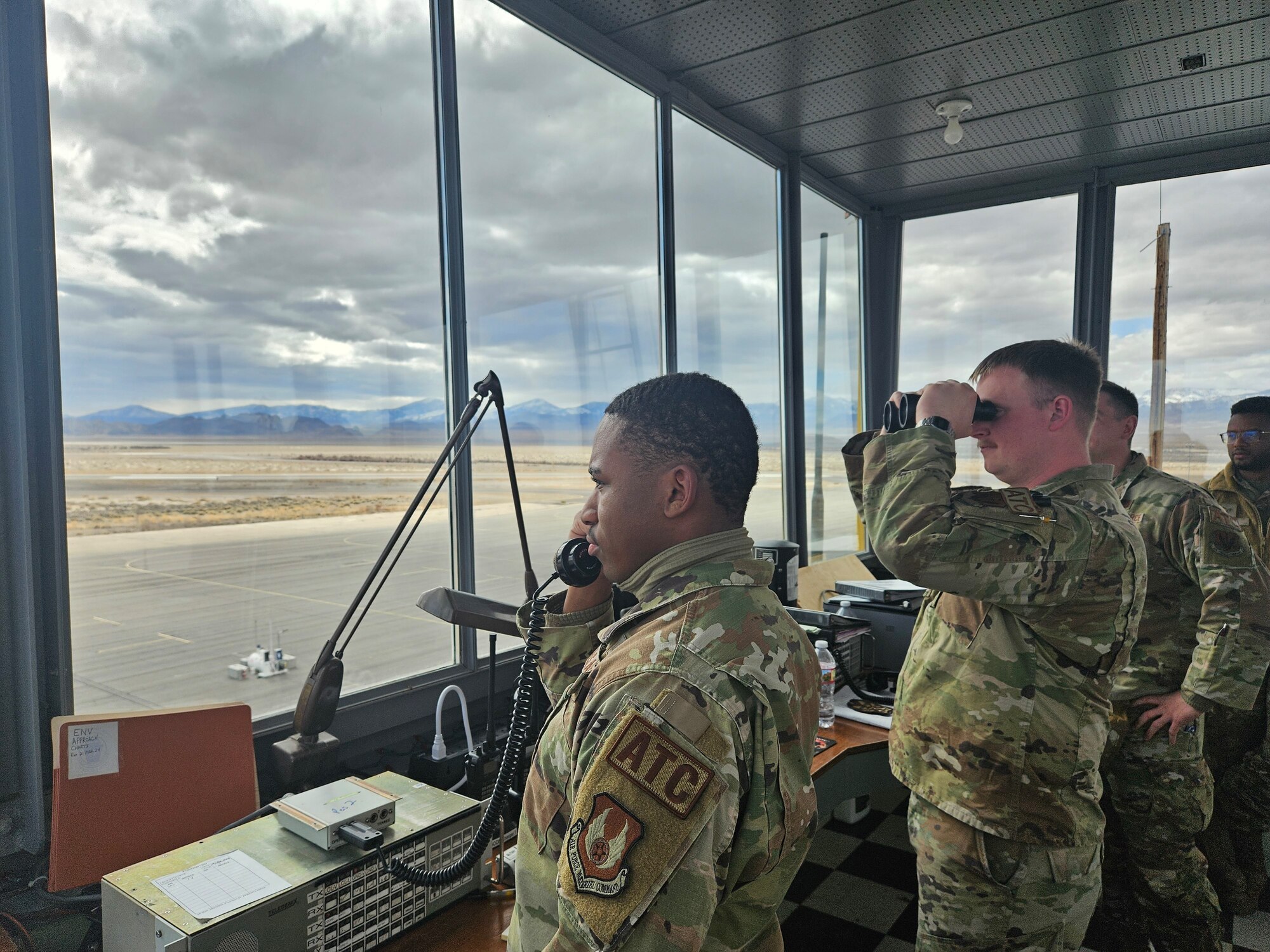 Air traffic controllers from the 75th Operations Support Squadron watch over the airfield from inside a World War II tower facility.