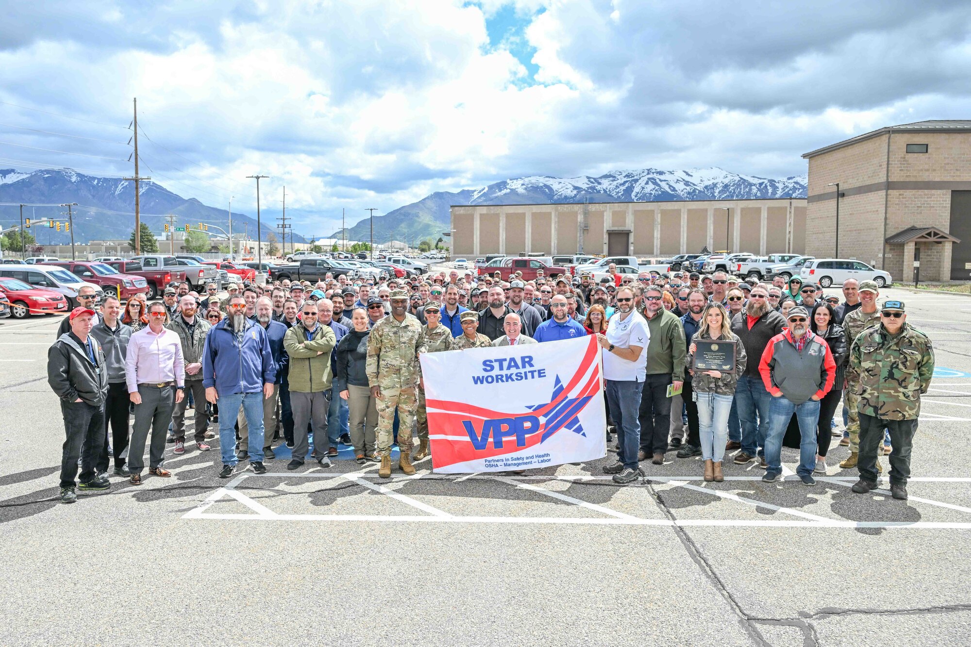 Several employees with the 309th Missile Maintenance Group pose for a group photo holding the VPP Star certification banner.