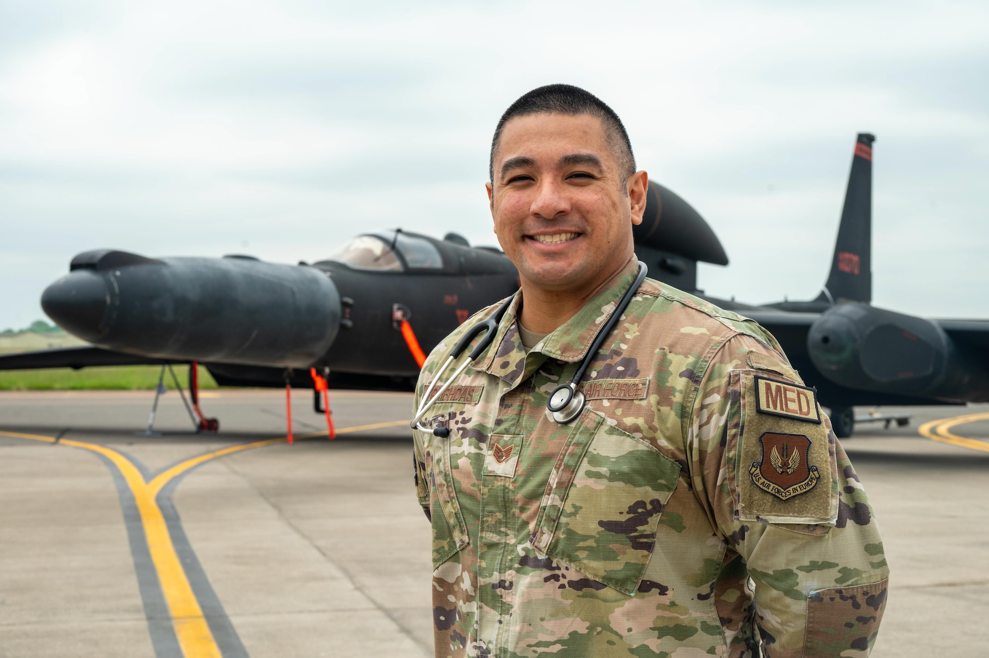 An Airman smiles while standing in front of a U-2
