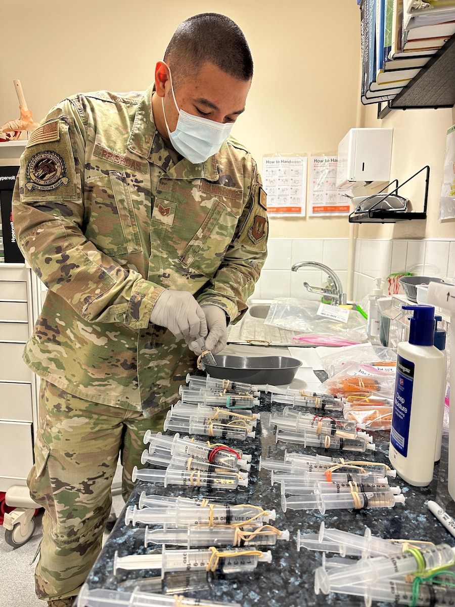 A medical technician fills syringes